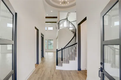 a view of a hallway with wooden floor and staircase