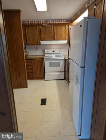 a kitchen with a refrigerator sink and cabinets