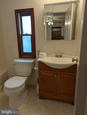 a bathroom with a toilet sink and mirror