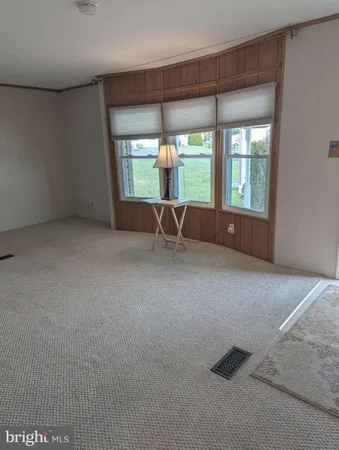 an empty room with windows and ceiling fan