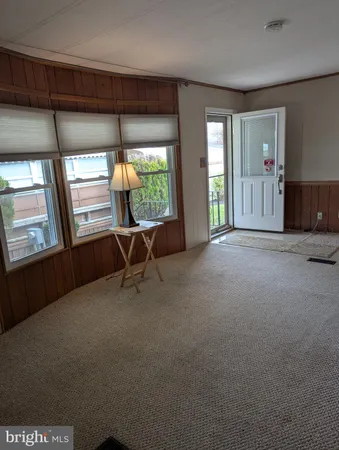 a view of an empty room with furniture and a window