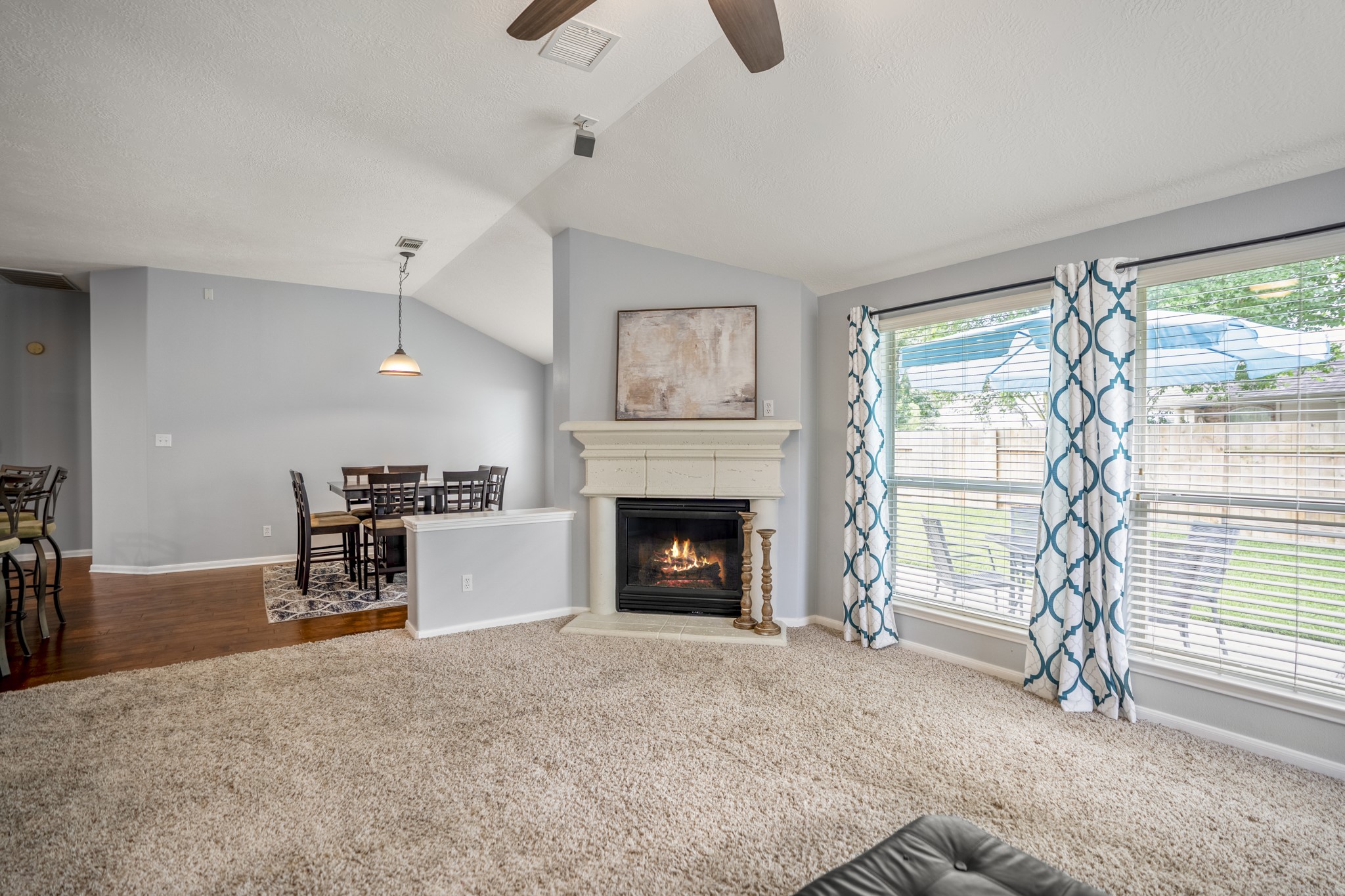 3411 Utah Beach Court Spring, TX 77388 - Photo 17 of 50 Continuing into the family room, the back of the home opens into a comfortable gathering space with the gas log fireplace on the left and glass doors leading directly to the patio. The kitchen and breakfast room remain open through the left-side opening, keeping the main living areas connected without feeling crowded.
