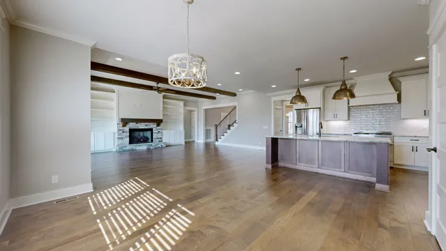 a kitchen with stainless steel appliances granite countertop a sink a stove a refrigerator cabinets and wooden floor