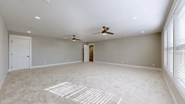 an empty room with closet and windows