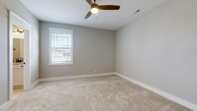 a view of a room with a ceiling fan and a window