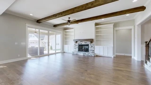a view of empty room with wooden floor and fireplace