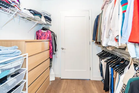 a view of walk in closet with clothes and shoes