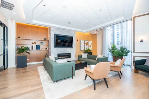 a living room with furniture a flat screen tv and a large window
