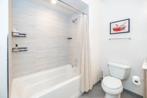 a white toilet sitting next to a bath tub