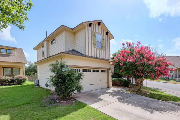 a front view of a house with a tree