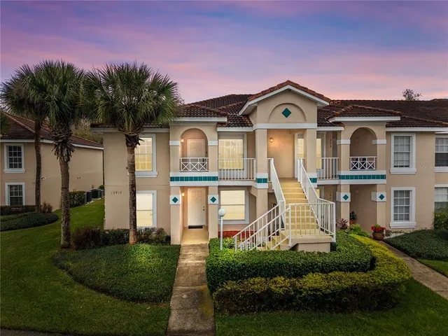 a front view of a house with a yard and potted plants