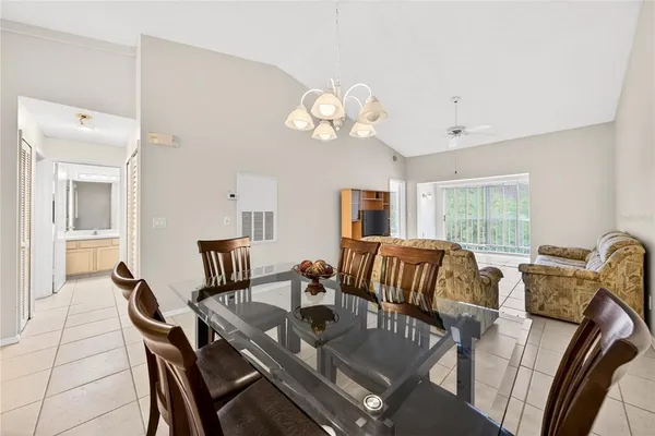a view of a dining room with furniture a chandelier and a window