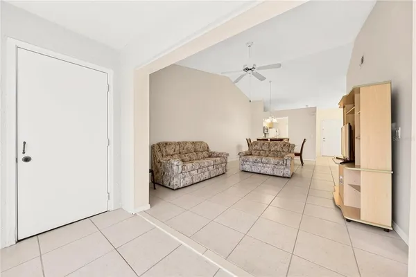 a living room with furniture and a refrigerator