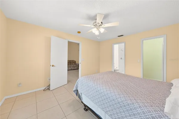 a spacious bedroom with a bed and a chandelier