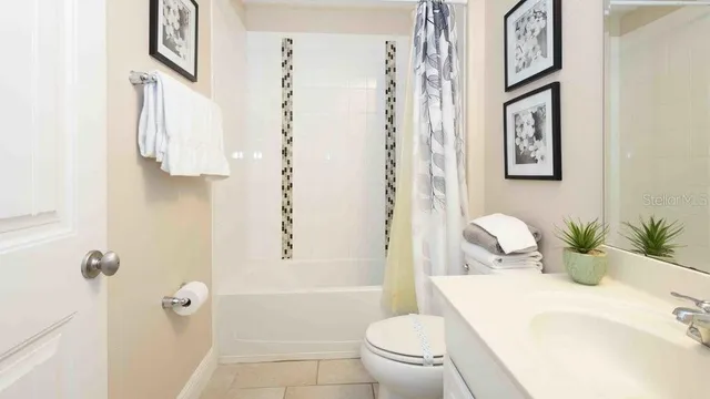 a bedroom with a bed and a lamp on dresser