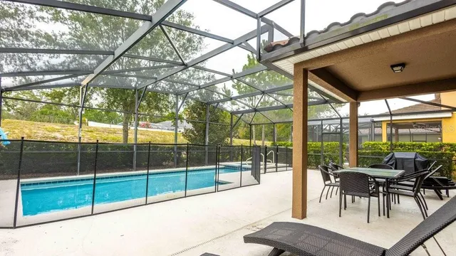 a view of a swimming pool with a patio and a yard
