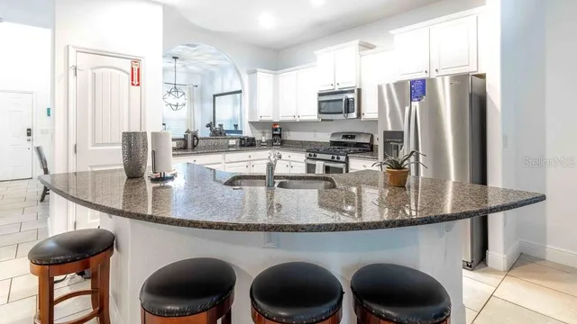 a kitchen with granite countertop white cabinets and stainless steel appliances