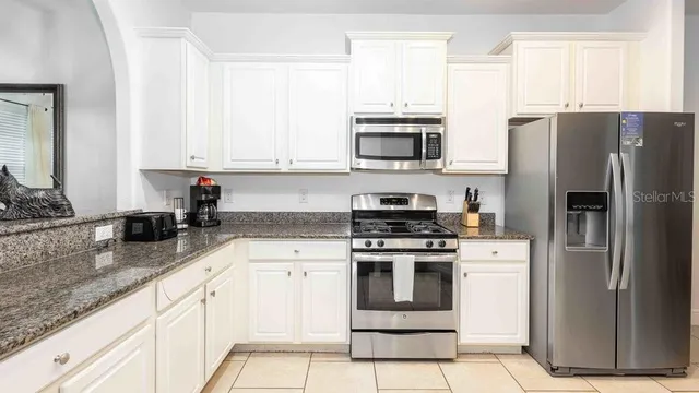 a kitchen with stainless steel appliances granite countertop a sink stove and microwave
