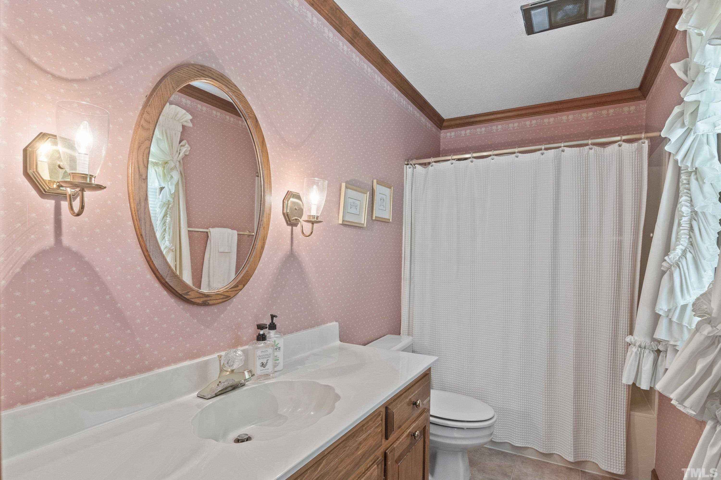 8501 Crowder Road Raleigh, NC 27603 - Photo 30 of 60 a bathroom with a toilet a sink and a mirror