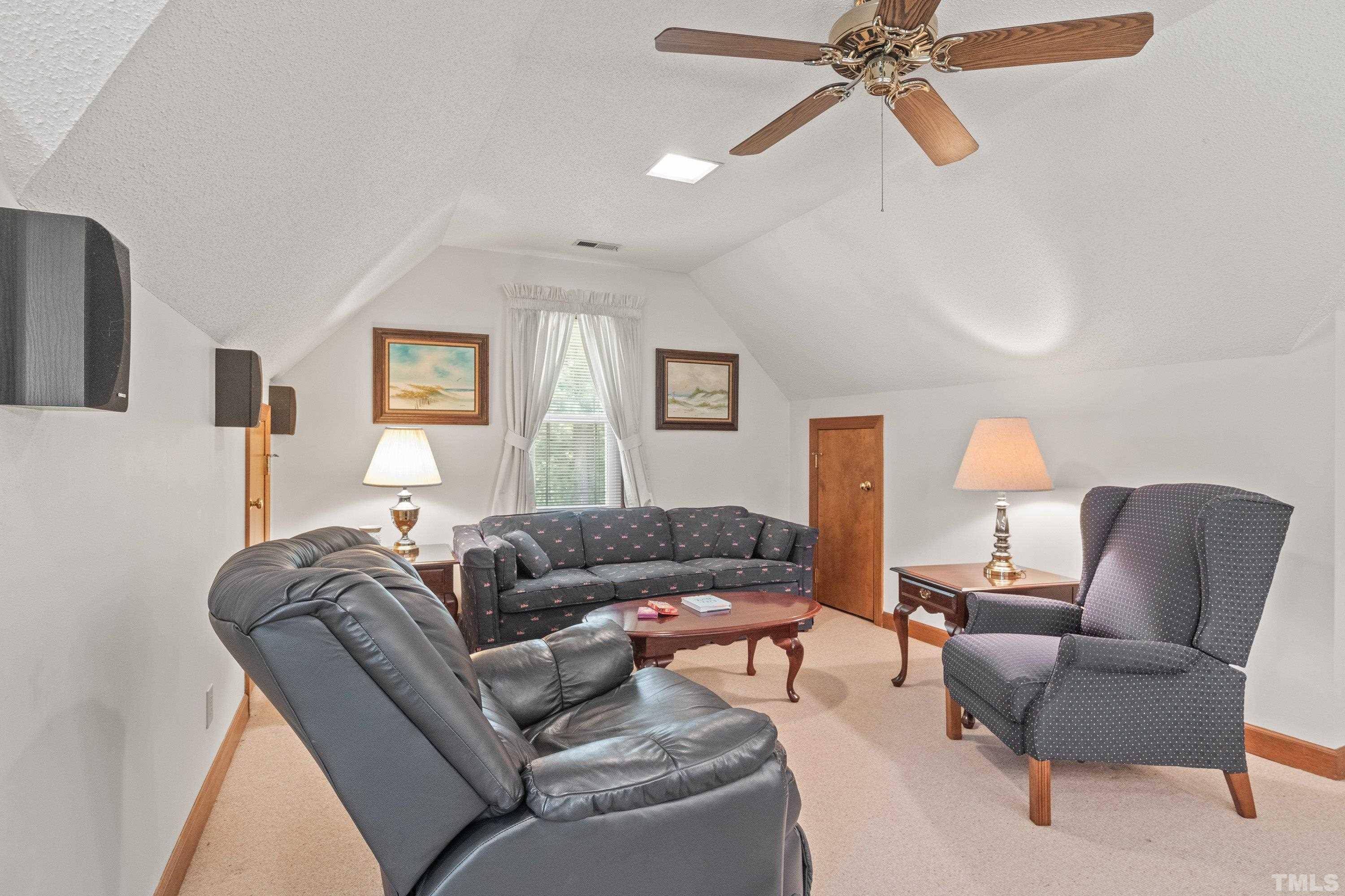 8501 Crowder Road Raleigh, NC 27603 - Photo 34 of 60 a living room with furniture and a lamp