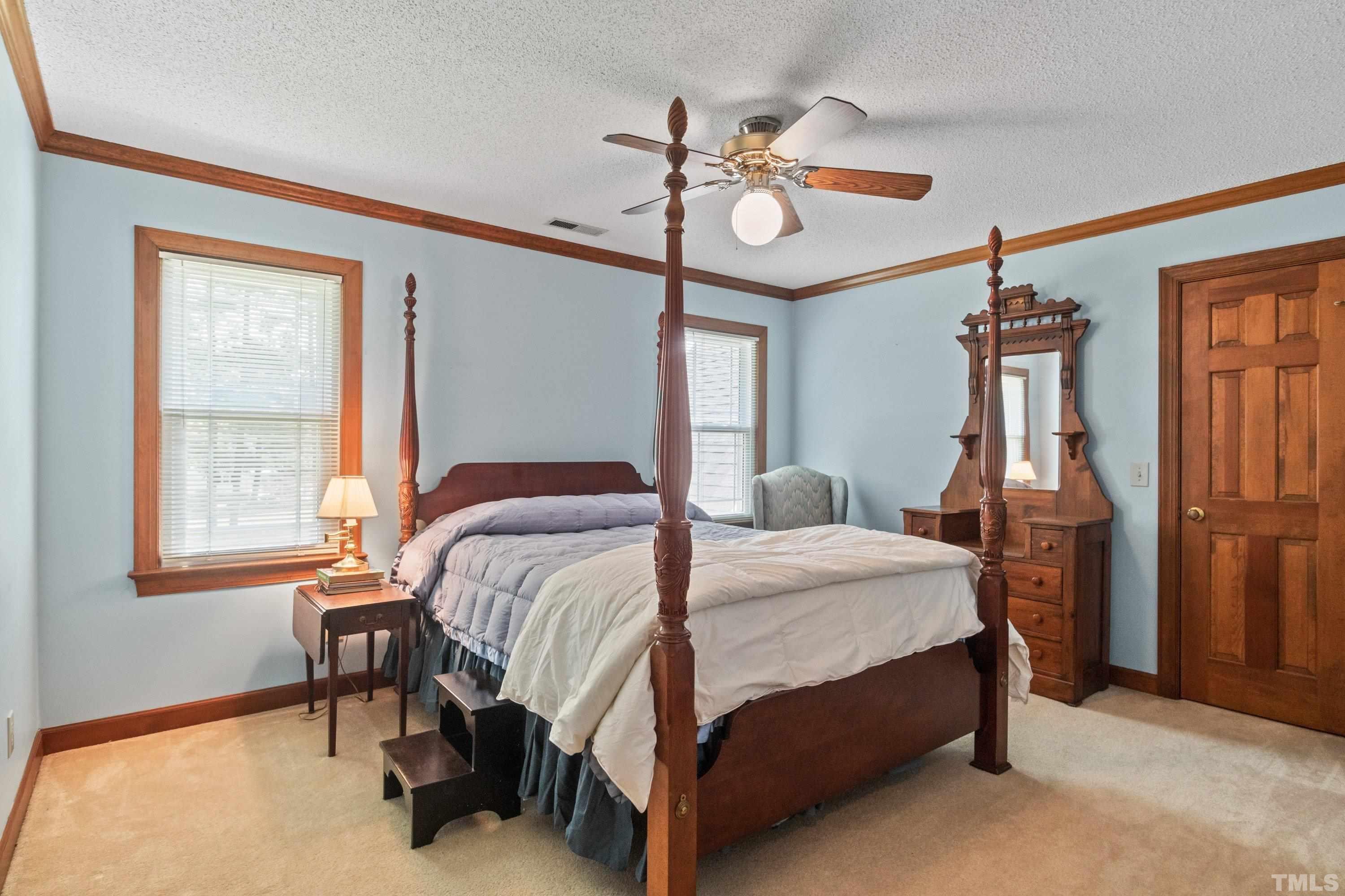 8501 Crowder Road Raleigh, NC 27603 - Photo 47 of 60 a bedroom with a bed and a chandelier