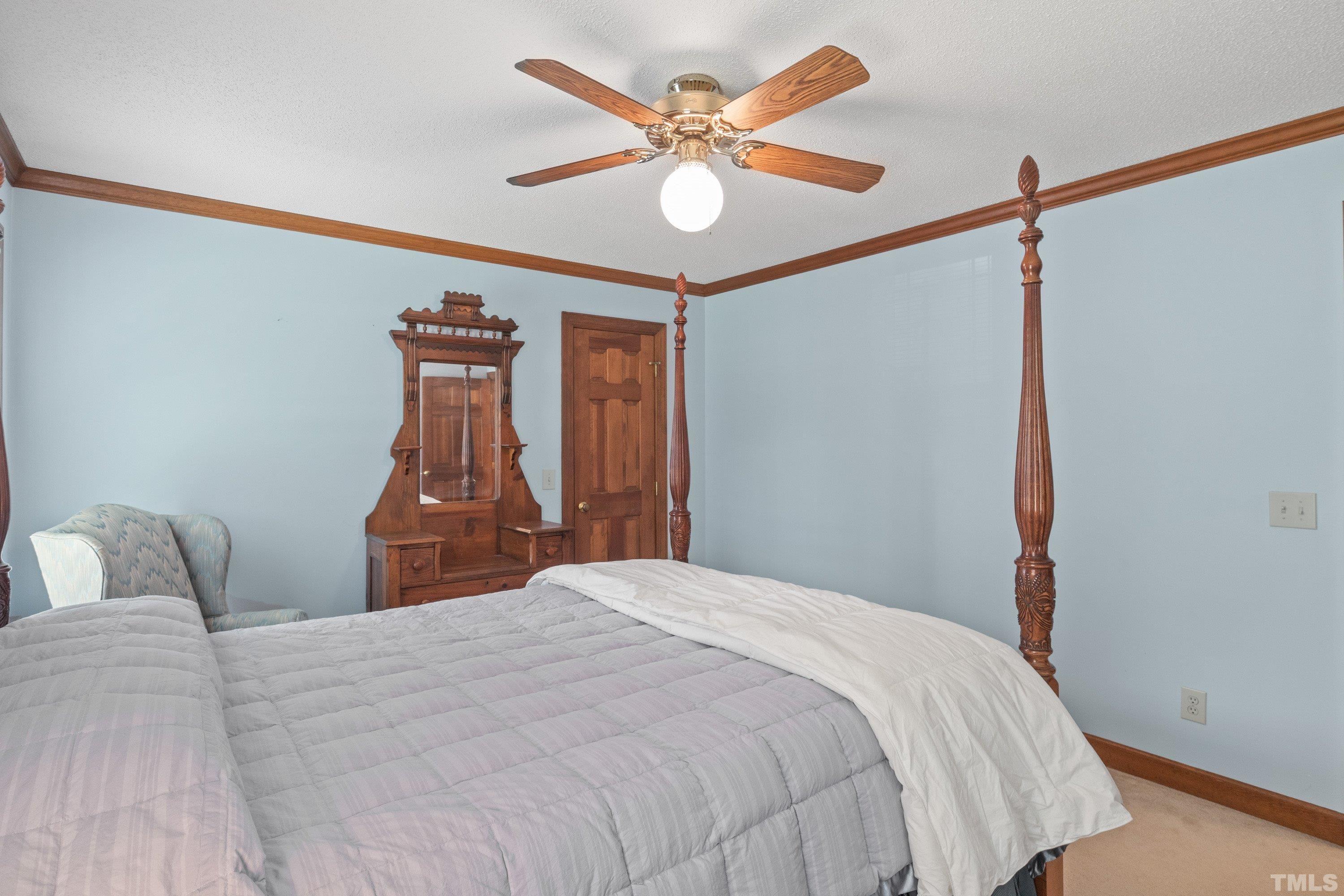 8501 Crowder Road Raleigh, NC 27603 - Photo 48 of 60 a bedroom with a bed and a chandelier