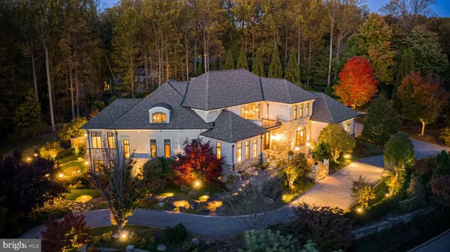 a living room with stainless steel appliances kitchen island granite countertop furniture a fireplace and a chandelier