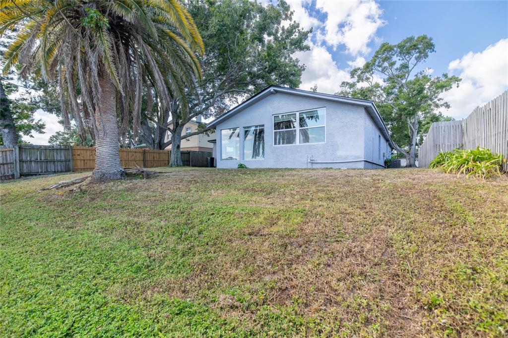 12417 84th Way Largo, FL 33773 - Photo 21 of 27 a yellow house with a big yard and large trees
