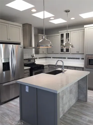 a kitchen with kitchen island a sink stainless steel appliances and cabinets