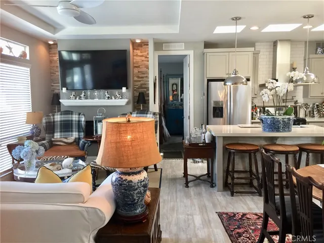 a living room with furniture a flat screen tv and kitchen view