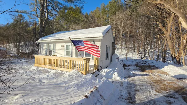 a view of a white house with a large tree