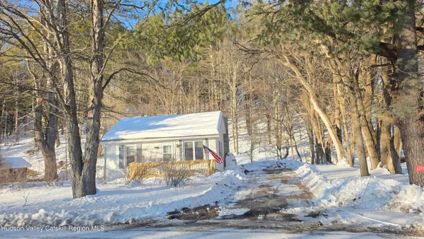a view of a white house with a large tree
