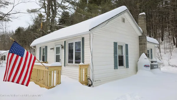 a view of a house with a yard covered in snow