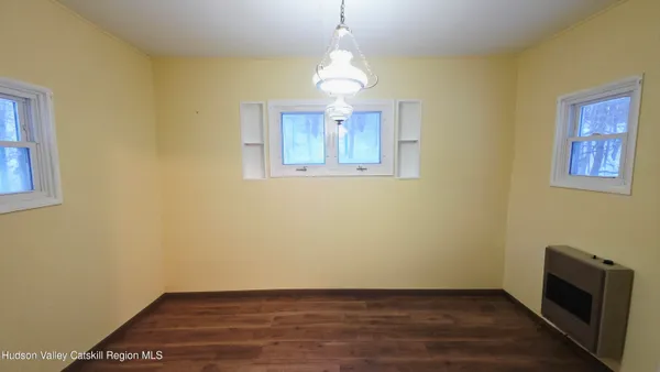 a view of empty room with wooden floor and windows