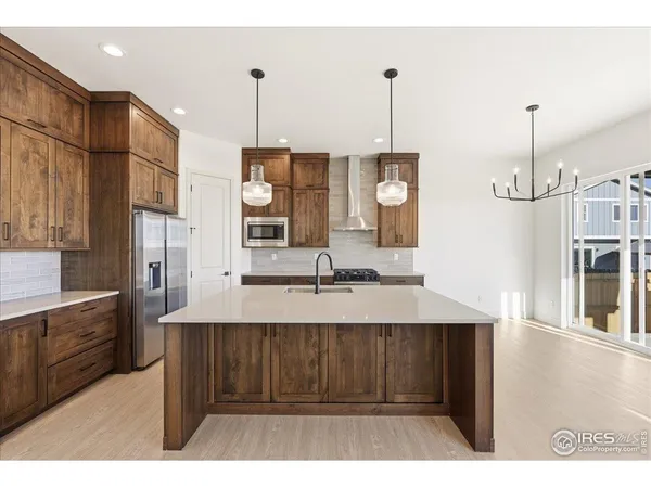 a view of a kitchen with stainless steel appliances granite countertop a sink a stove and a wooden floors
