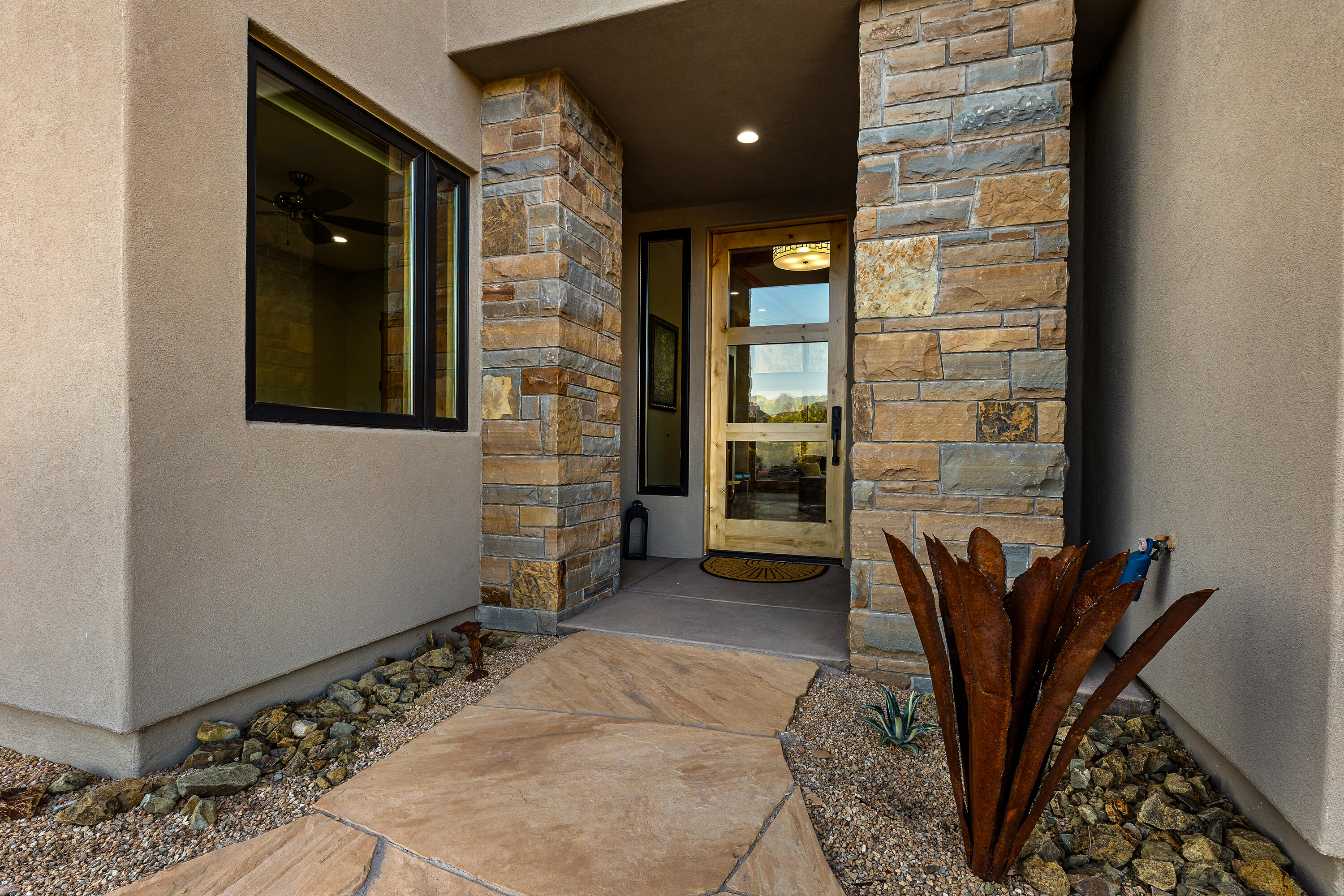 3000 Navajo Way Springdale, UT 84767 - Photo 15 of 63 Covered front entry with stone accent wall and a metal desert sculpture detail.