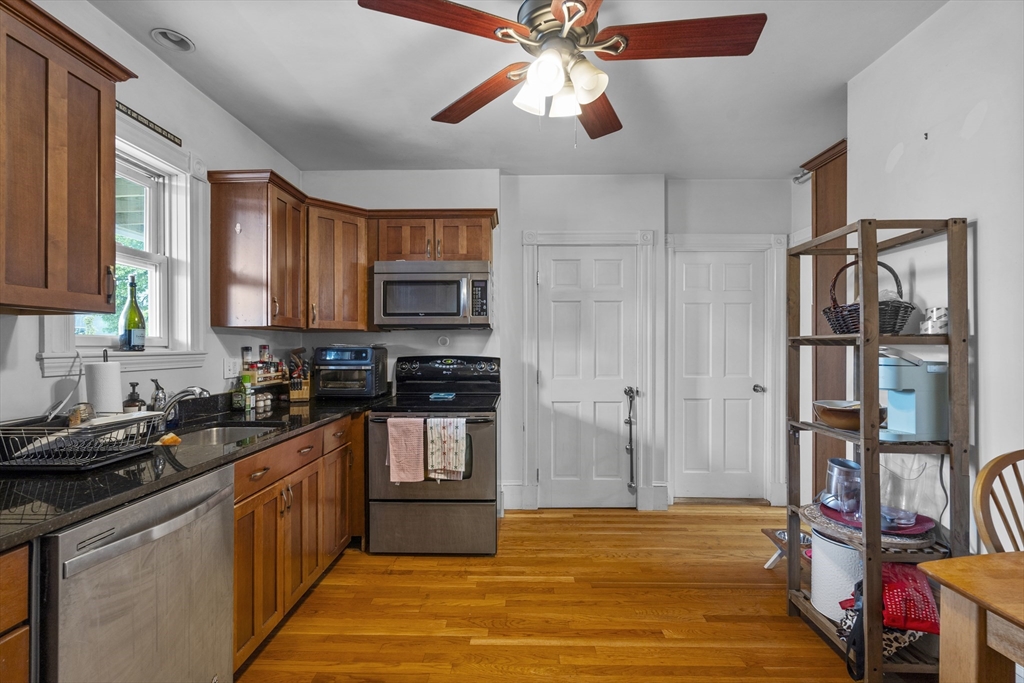 733 East 3rd Street Boston, MA 02127 - Photo 7 of 12 a kitchen with stainless steel appliances granite countertop a refrigerator and a stove top oven
