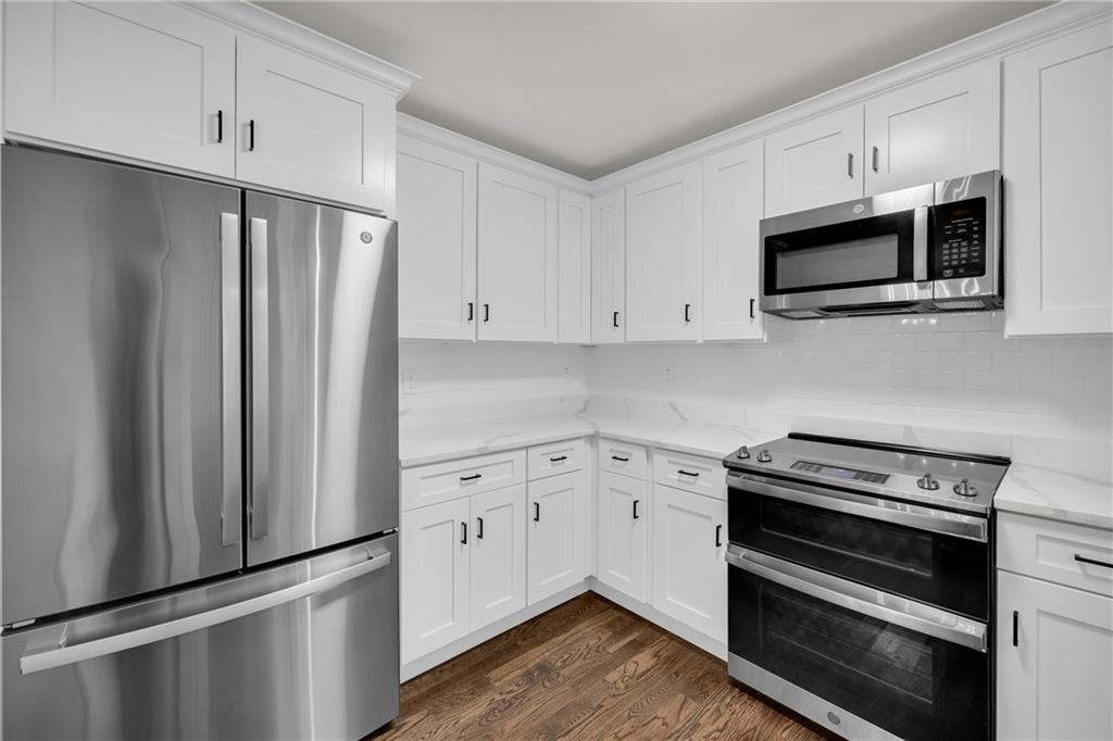 2941 Lake Hollow Road Gainesville, GA 30501 - Photo 15 of 53 a kitchen with stainless steel appliances white cabinets and wooden floor