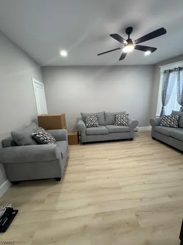 a living room with furniture and a ceiling fan