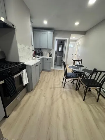 a kitchen with granite countertop a sink cabinets and stainless steel appliances