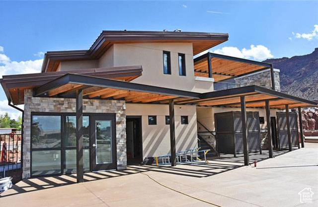 2331 Mesa Road, Unit E3 Moab, UT 84532 - Photo 37 of 71 Rear view of property featuring stone siding, stucco siding, a mountain view, and a patio area