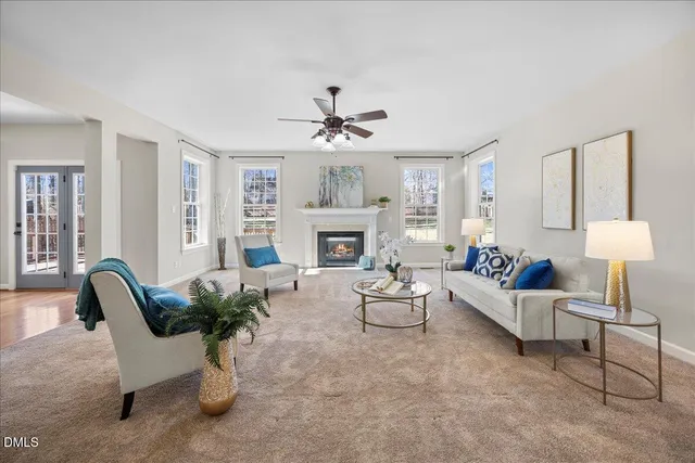 a living room with furniture and a dining table with kitchen appliances