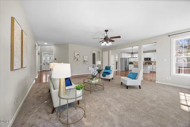 an empty room with chandelier fan and windows