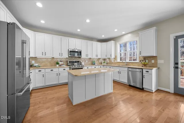 a kitchen with a refrigerator a stove top oven a sink and cabinets