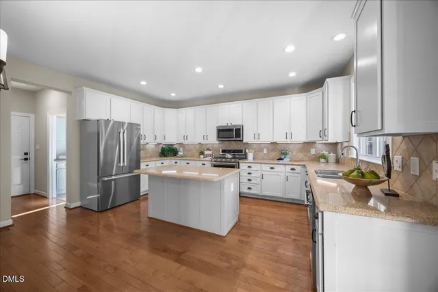 a kitchen with sink a refrigerator and wooden floor