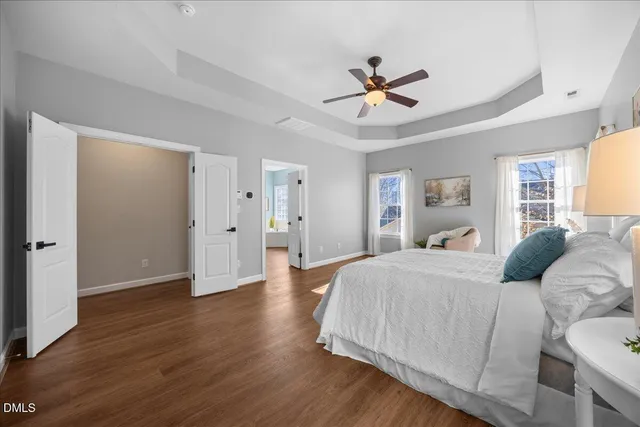 a large white kitchen with a lot of counter space and wooden floor