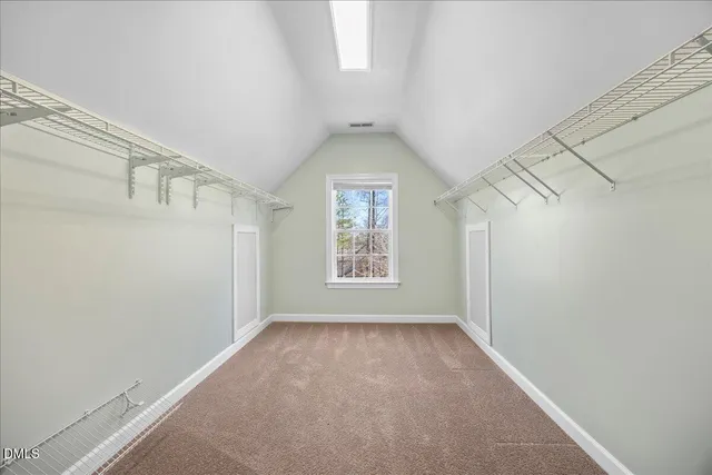 an empty room with wooden floor chandelier fan and windows