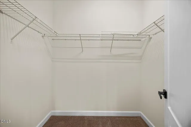 an empty room with wooden floor chandelier fan and windows