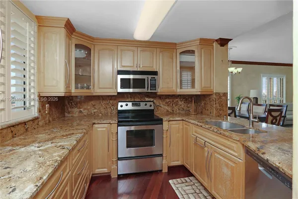 a kitchen with stainless steel appliances granite countertop a stove a sink and a microwave