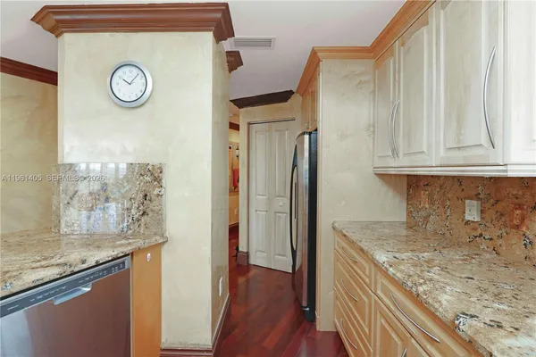 a view of a kitchen with fridge and wooden floor